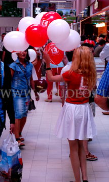 Balony reklamowe na patyczkach w czasie rozdawania przez hostessę.